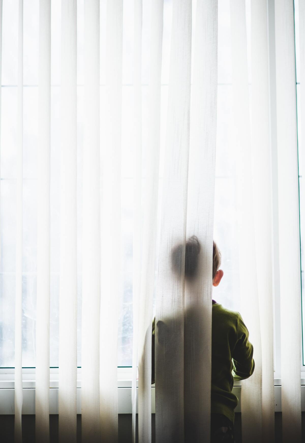 child standing by the window