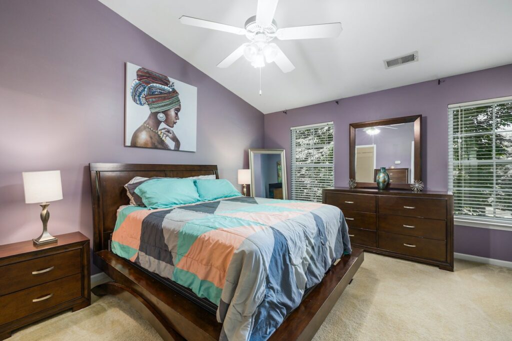 A Bedroom With Brown Wooden Furniture and window roller shade